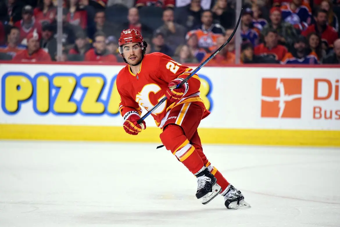 Hockey player in red Calgary Flames uniform skating on ice during a game.