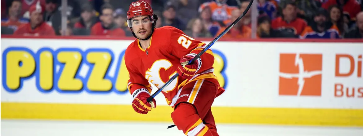 Hockey player in red Calgary Flames uniform skating on ice.