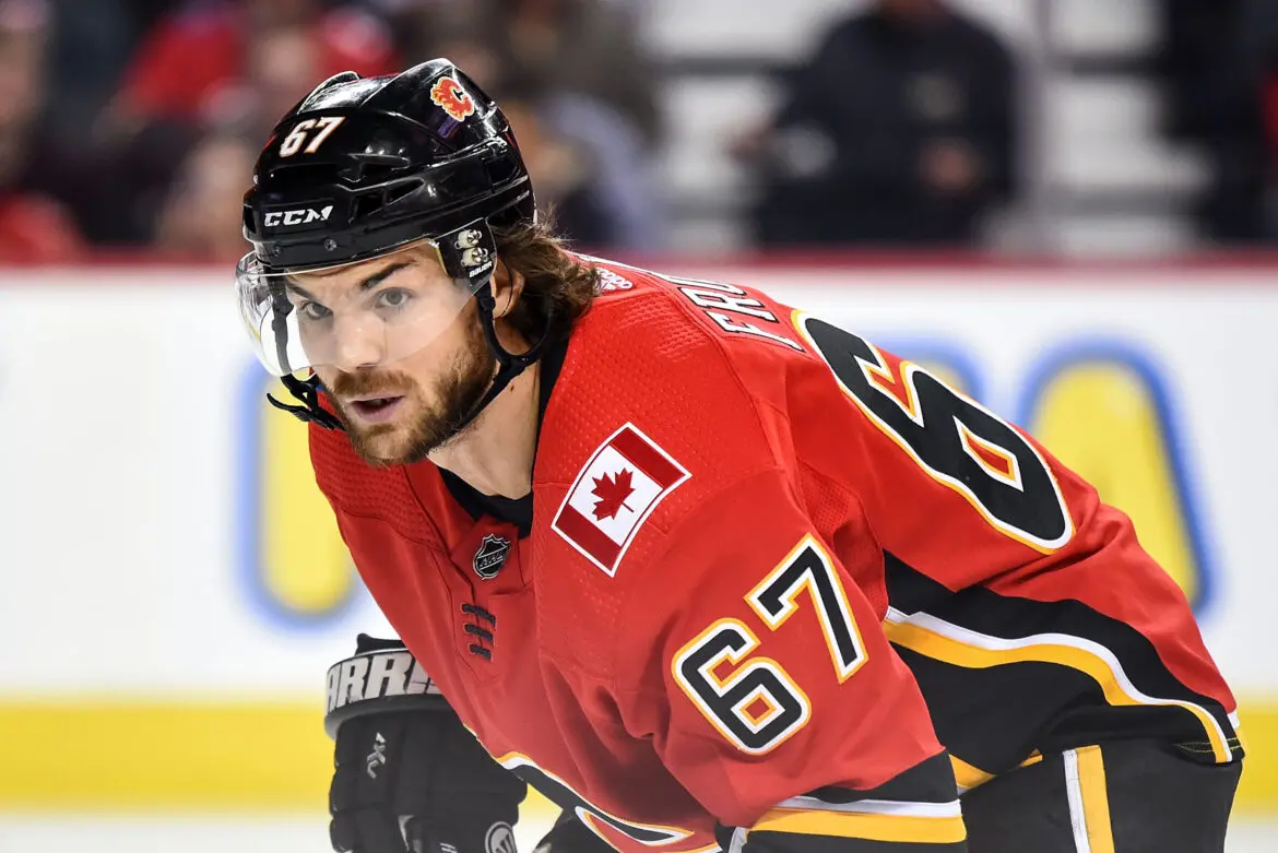 Ice hockey player in red jersey focused during a game.