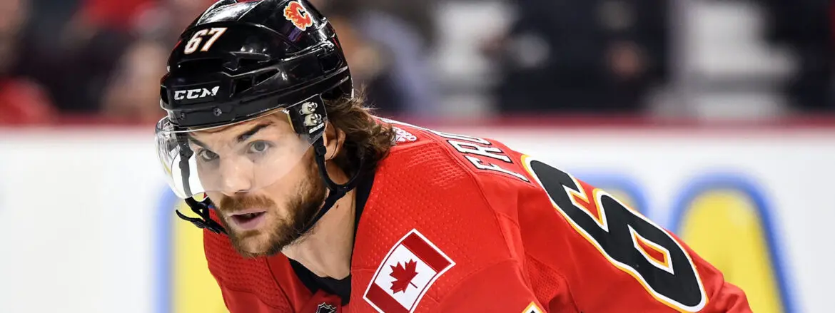 Ice hockey player in red Canadian jersey focused on the game.
