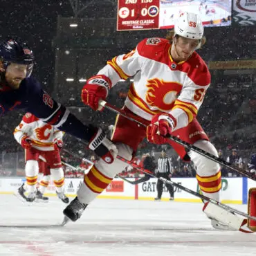 Ice hockey players in action during a fast-paced game on an outdoor rink.