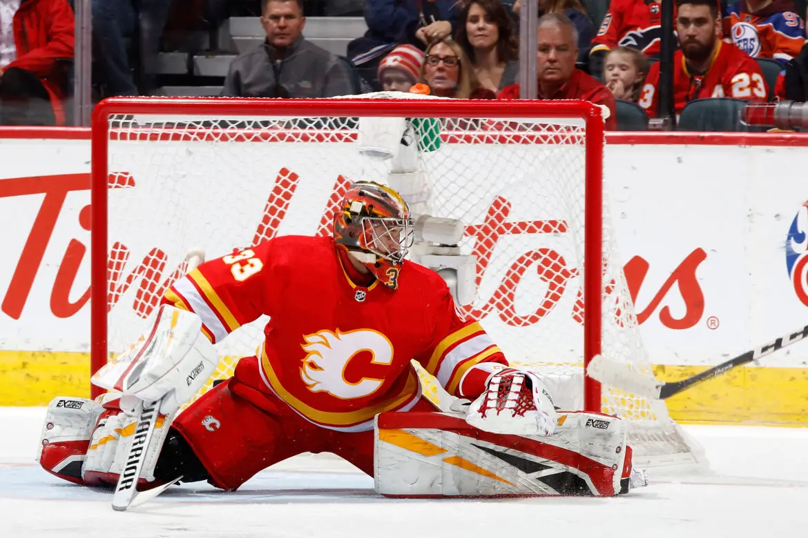 Calgary Flames goalie making a save during a hockey game.