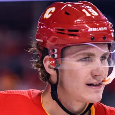 Close-up of a hockey player wearing a red helmet and jersey.