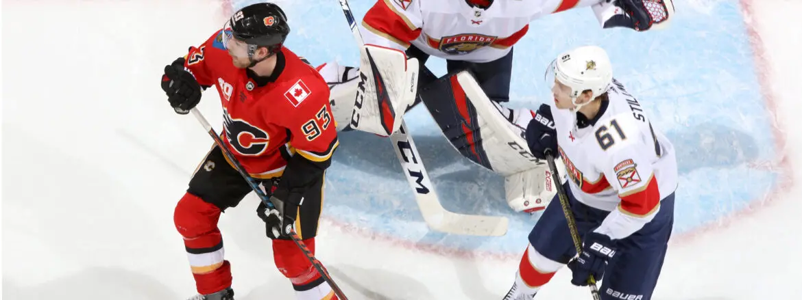 Two ice hockey players in action near the goal crease.