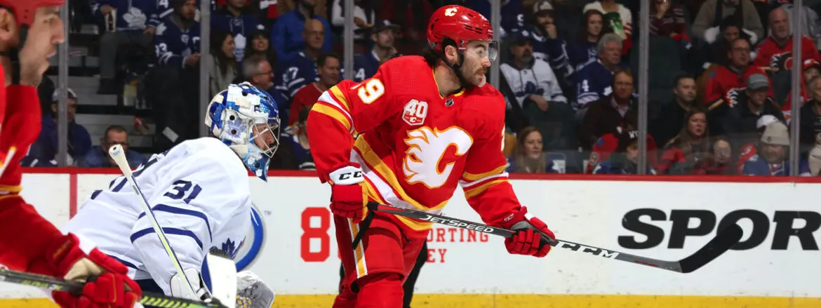 Hockey player in red Calgary Flames uniform on ice during a game.