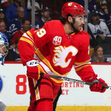 Hockey player in red Calgary Flames uniform on ice during a game.