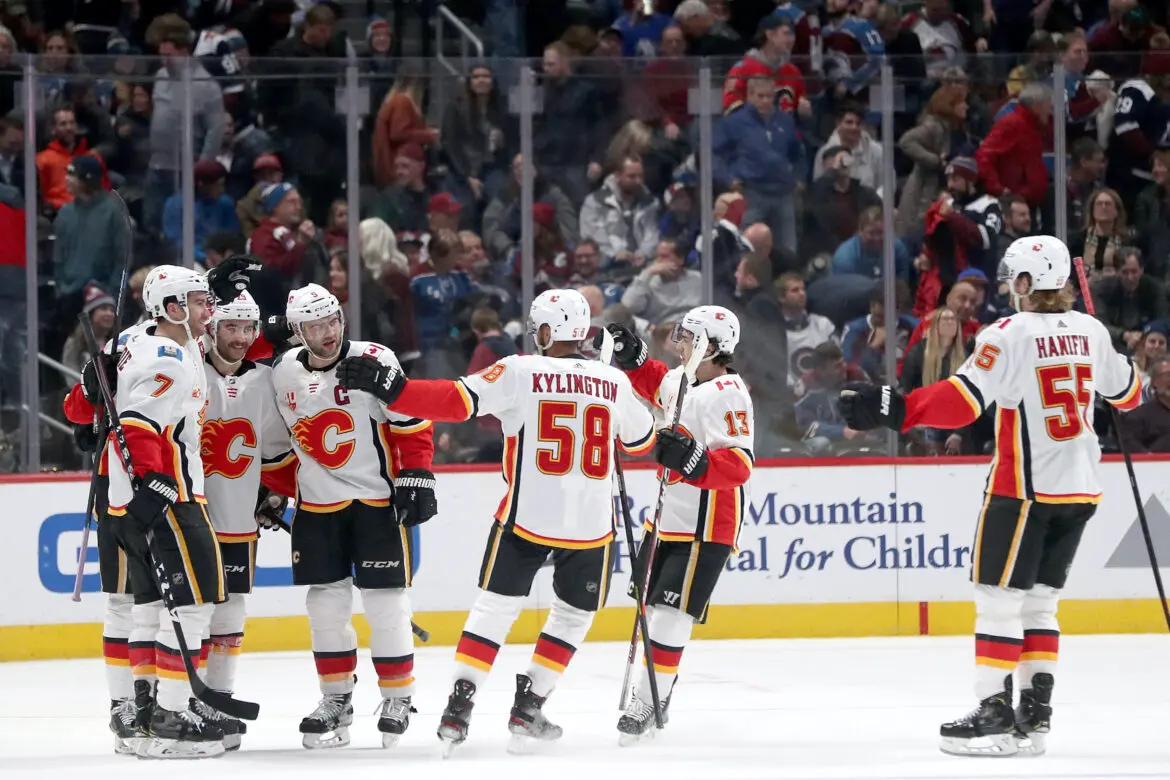 Calgary Flames hockey players celebrate a goal on the ice.