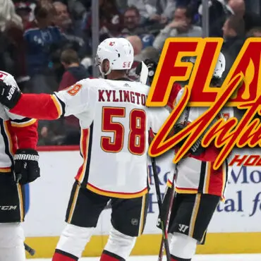 Calgary Flames players celebrating a goal during a hockey game.