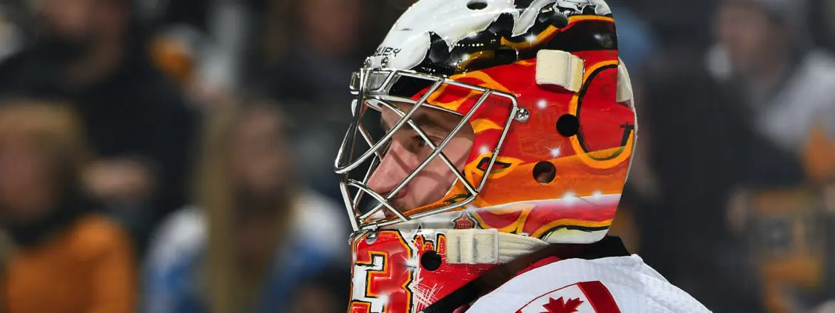 Close-up of a hockey goalie in a fiery-themed mask.