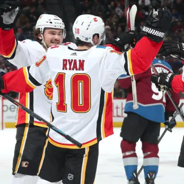 Hockey players celebrating a goal on the ice rink.