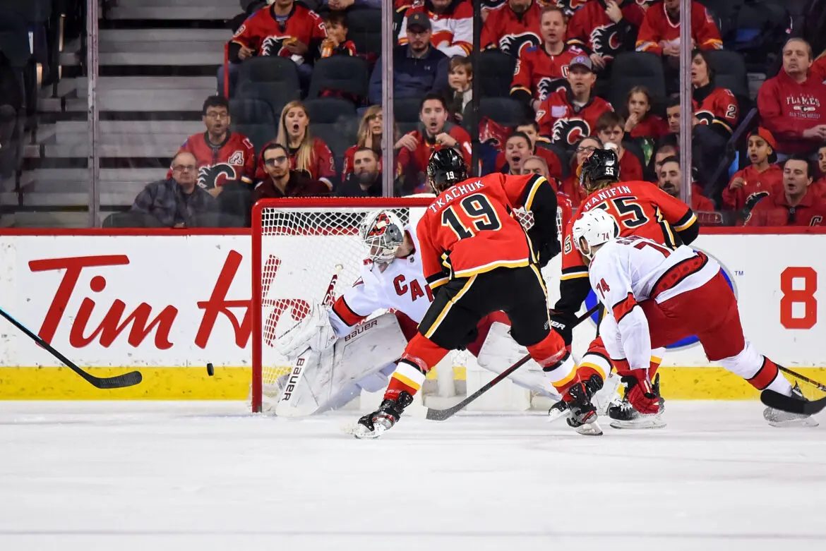 Hockey players compete intensely near the goal during a game.