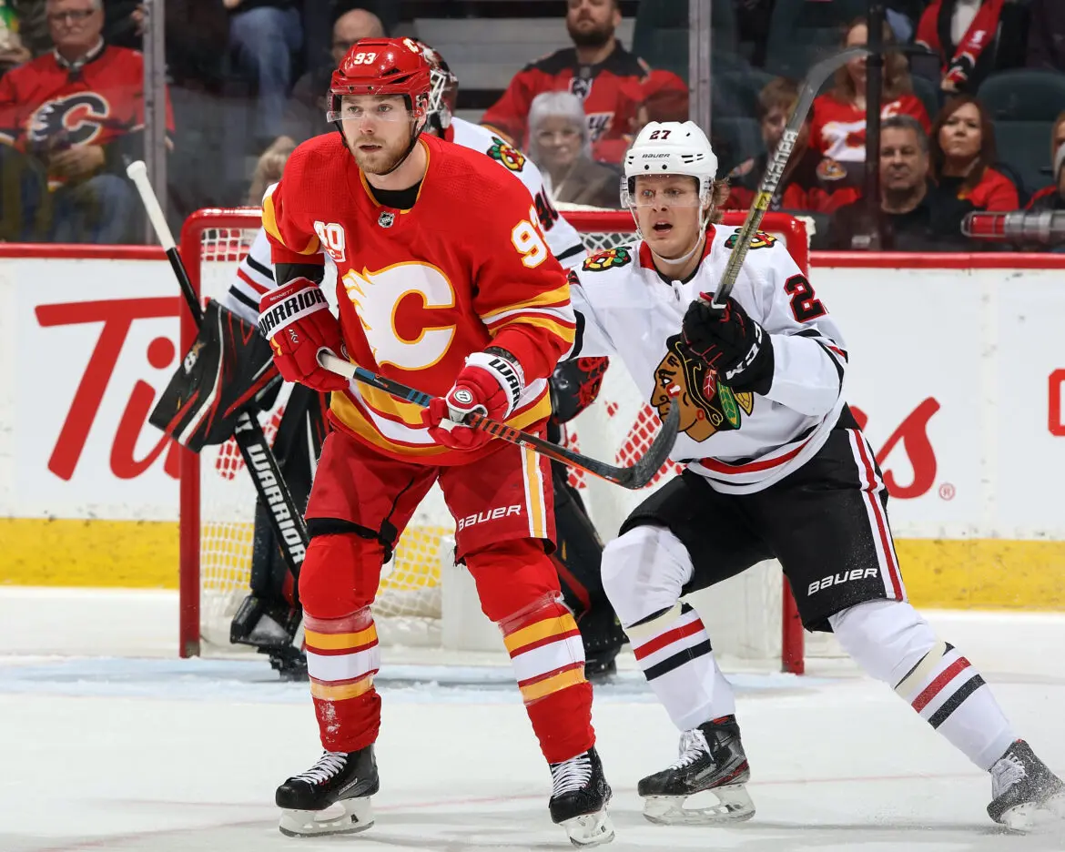 Two hockey players from Calgary Flames and Chicago Blackhawks in action.