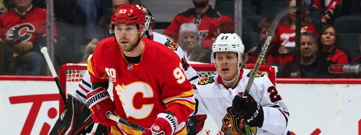 Two NHL players from Calgary Flames and Chicago Blackhawks in action during a game.
