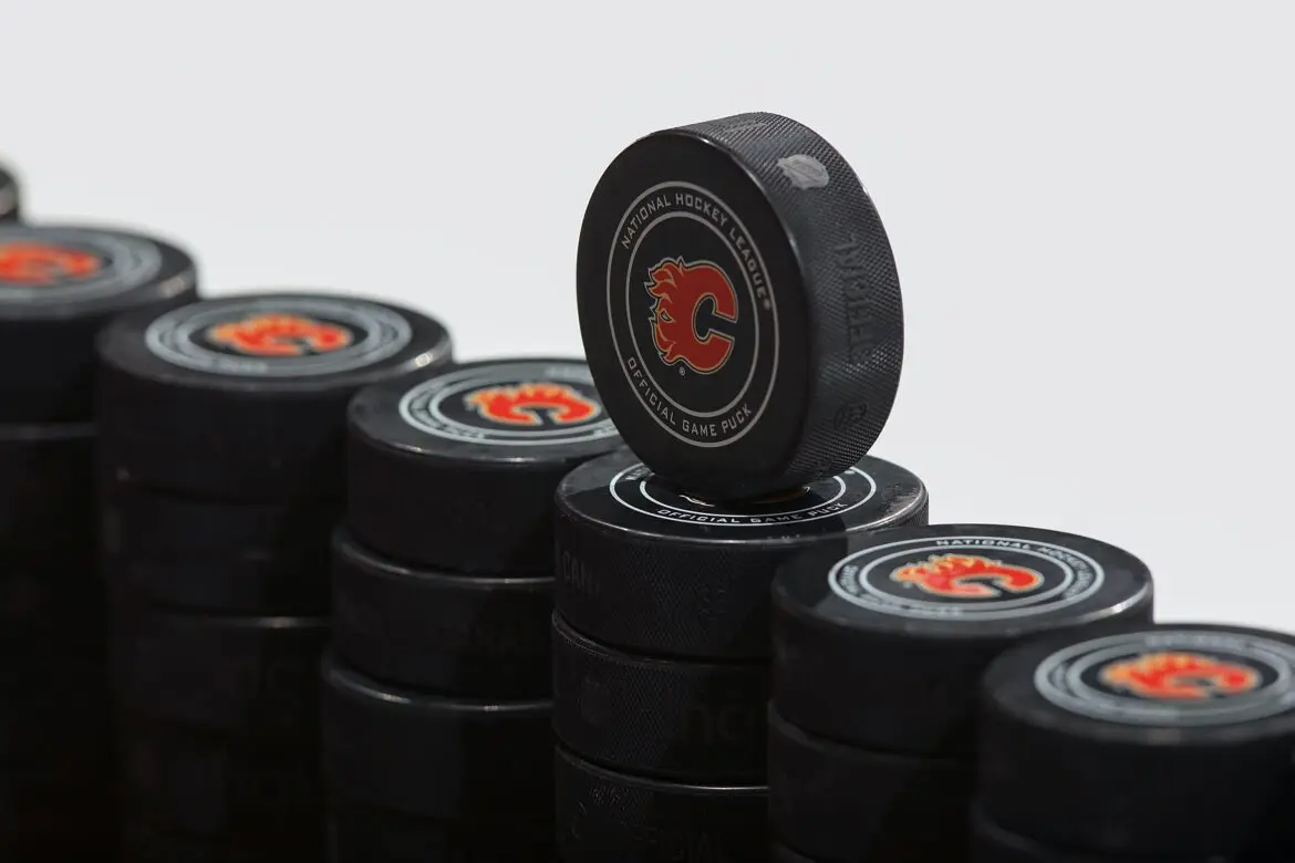 Stacked black hockey pucks with red logos on a white background.