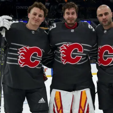 Three hockey players posing together in Calgary Flames jerseys.