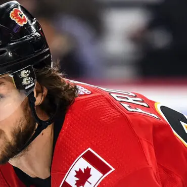 Hockey player in red jersey with Canadian flag patch on shoulder.