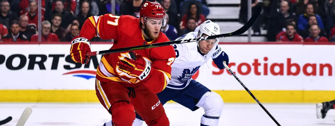 Two hockey players compete fiercely during a game.