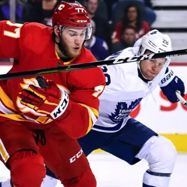 Two hockey players compete fiercely during a game.