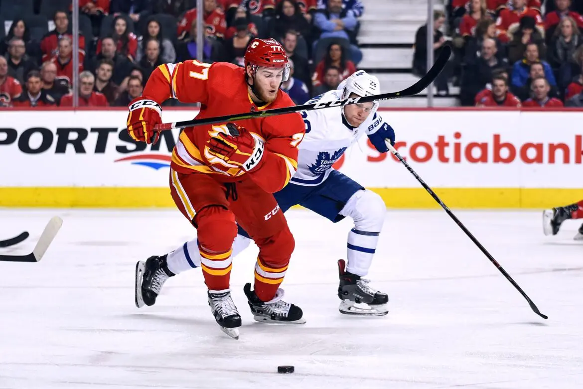 Two hockey players competing intensely on the ice rink.