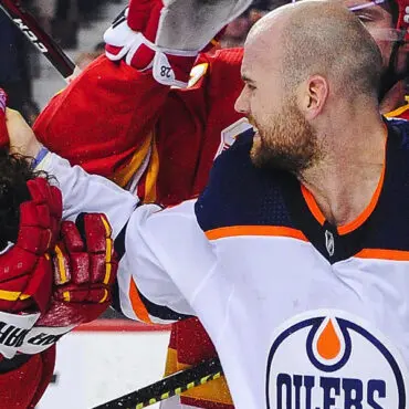 Hockey player in Edmonton Oilers uniform fist-bumping a teammate.