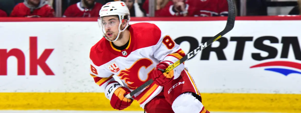 Hockey player in red and white uniform skating on ice.