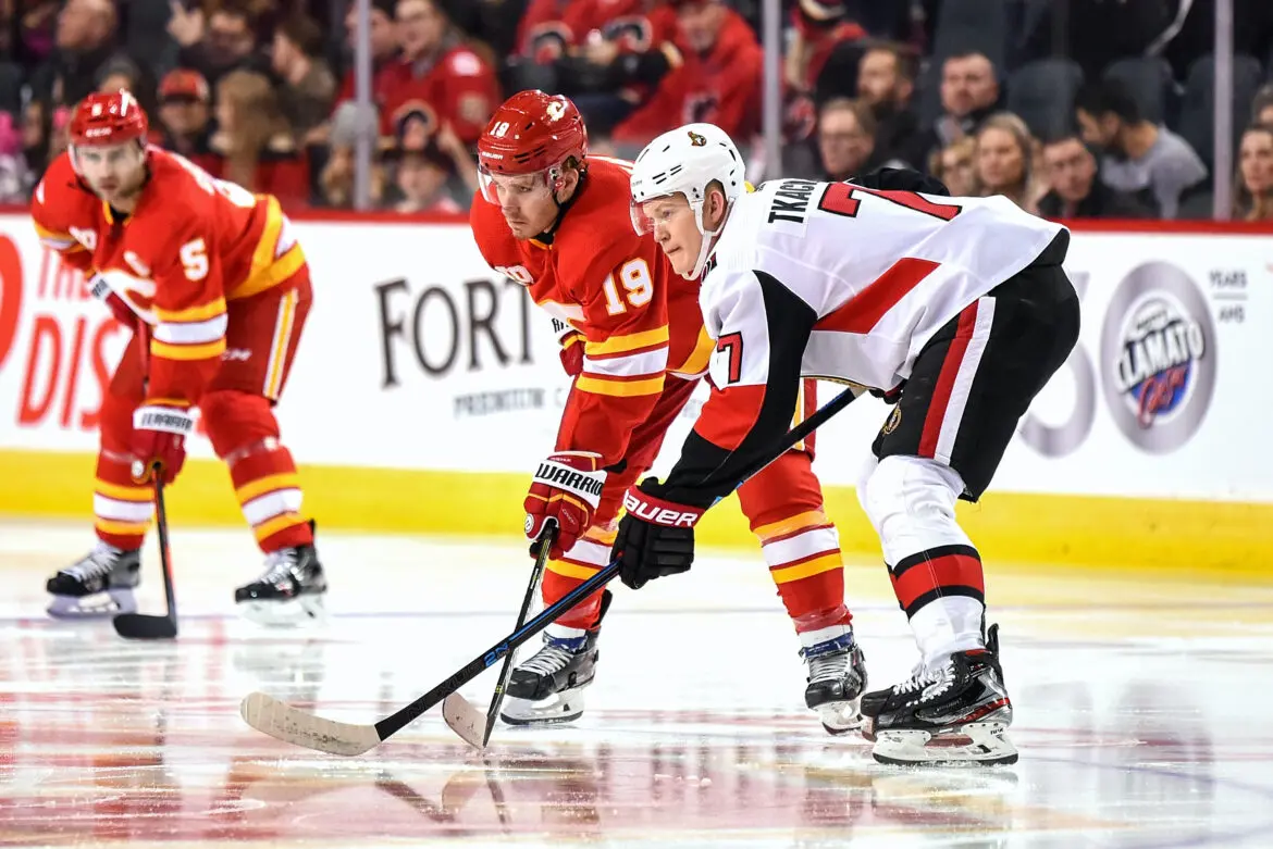 Two ice hockey players competing for the puck during a game.