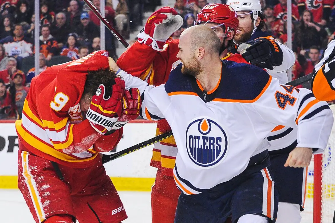 Two hockey players engaged in a heated fight on the ice.