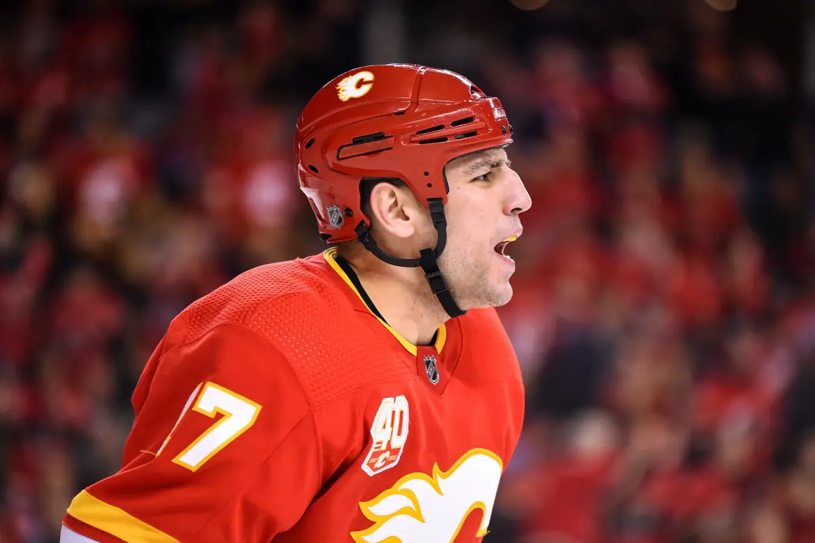 Hockey player in red Calgary Flames jersey during a game.