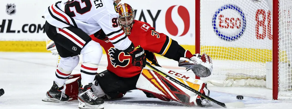 Calgary Flames goalie making a save during a hockey game.