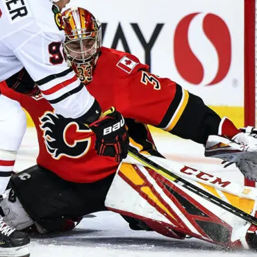 Calgary Flames goalie making a save during a hockey game.