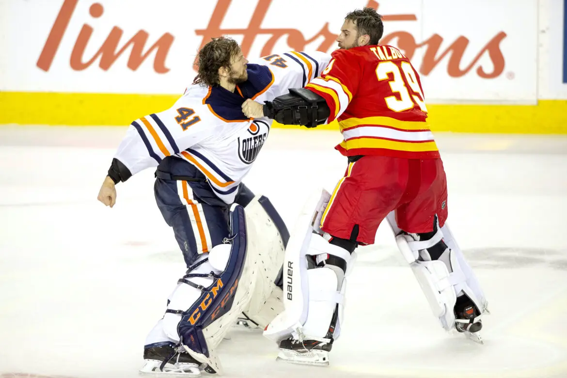 Two ice hockey goalies engaged in a fight during a game.