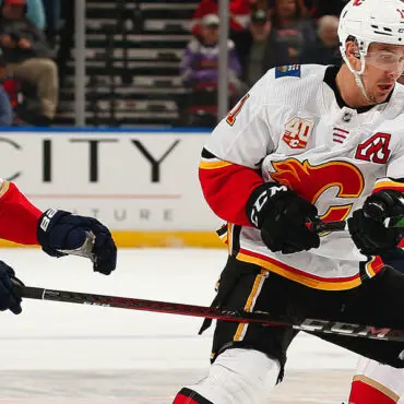Two hockey players in action during a game on the ice rink.