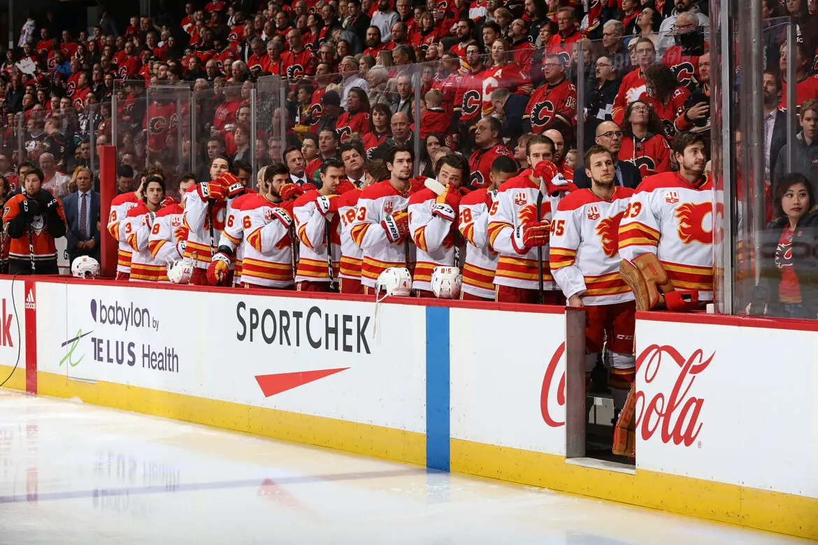 Calgary Flames hockey team lined up on the bench during a game.