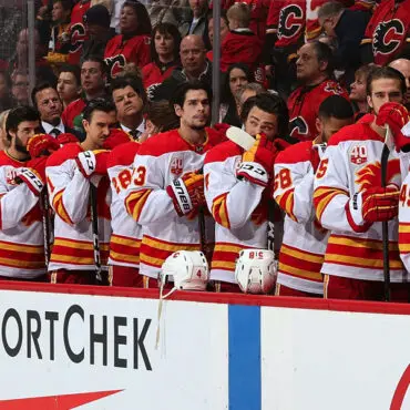 Calgary Flames hockey players stand for the anthem before a game.