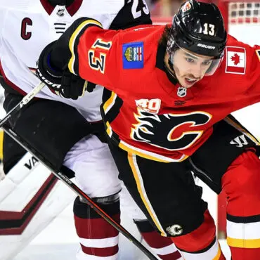 Hockey players from Calgary Flames and Arizona Coyotes compete intensely.
