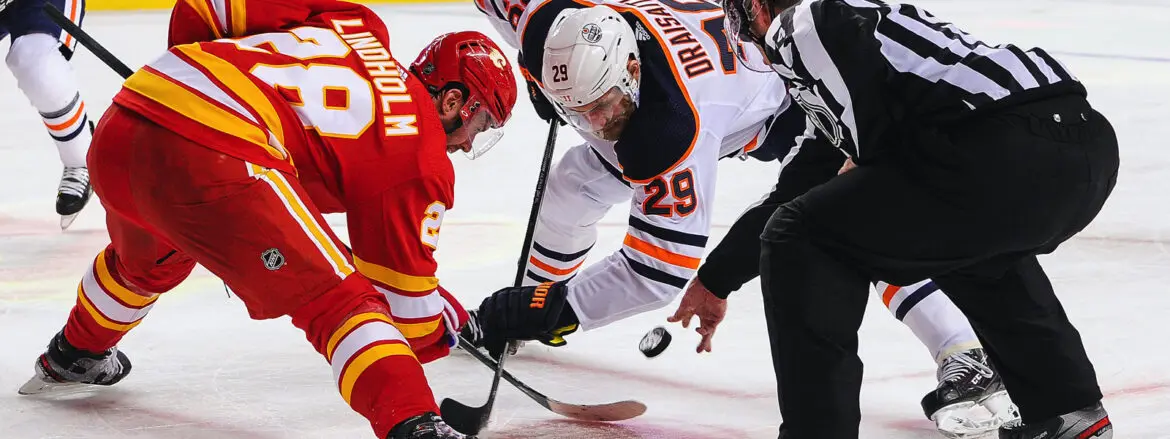 Two hockey players face off for the puck during a game.