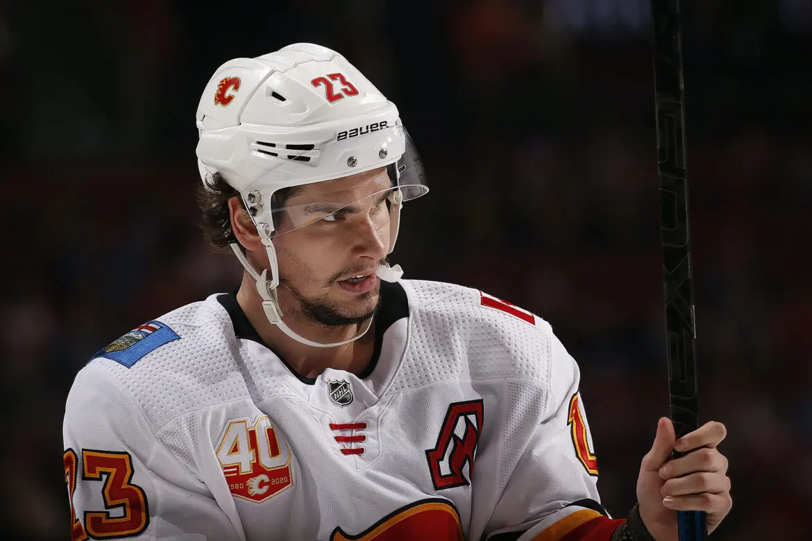 Ice hockey player in white jersey on the ice during a game.