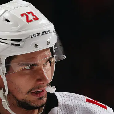 Close-up of a hockey player in a white helmet with number 23.