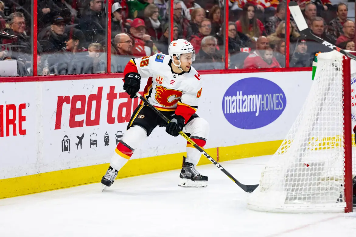 Hockey player in white and red jersey aiming for the goal during a game.