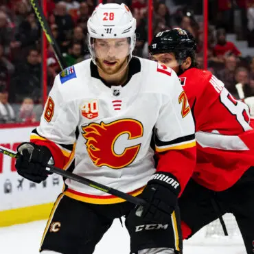 Hockey player in Calgary Flames uniform on ice during a game.
