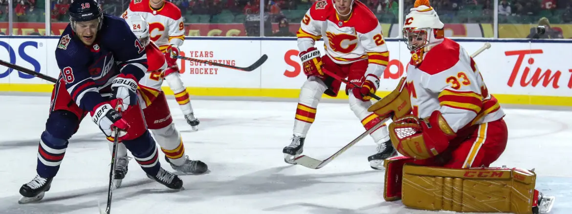 Two hockey players in red and yellow uniforms competing on ice.