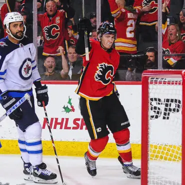 Calgary Flames player celebrates goal against Vancouver Canucks.