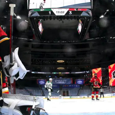 Ice hockey players in action during a game in an arena.