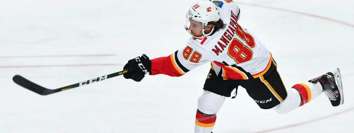 Hockey player in white and red jersey taking a shot on ice.
