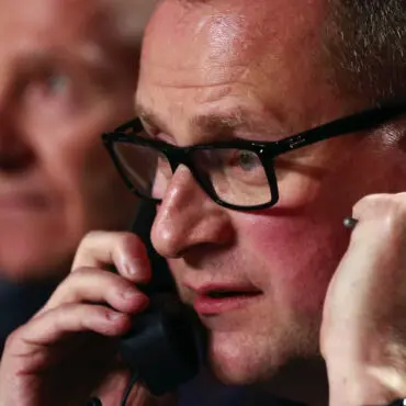 Man wearing glasses talking on the phone.