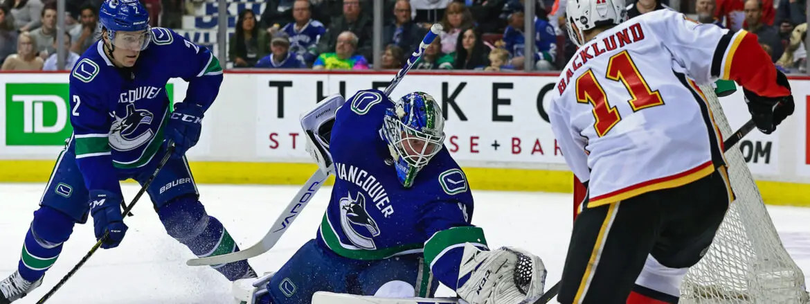 Vancouver Canucks goalie making a save during a hockey game.