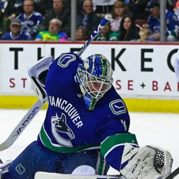 Vancouver Canucks goalie making a save during a hockey game.