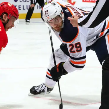 Two hockey players face off during a game.