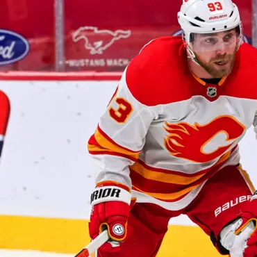 Calgary Flames player in red and white gear during a hockey game.