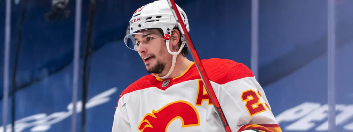 Hockey player in Calgary Flames uniform on the ice.